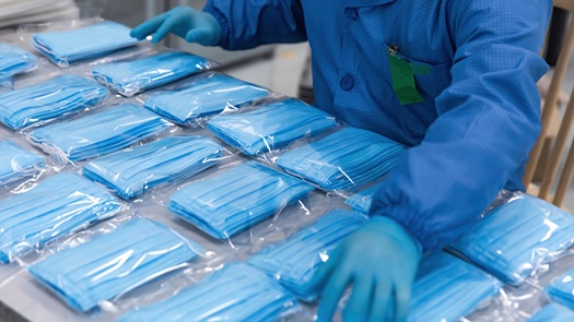 一个穿着蓝色医院统一的人通过面具的包裹。