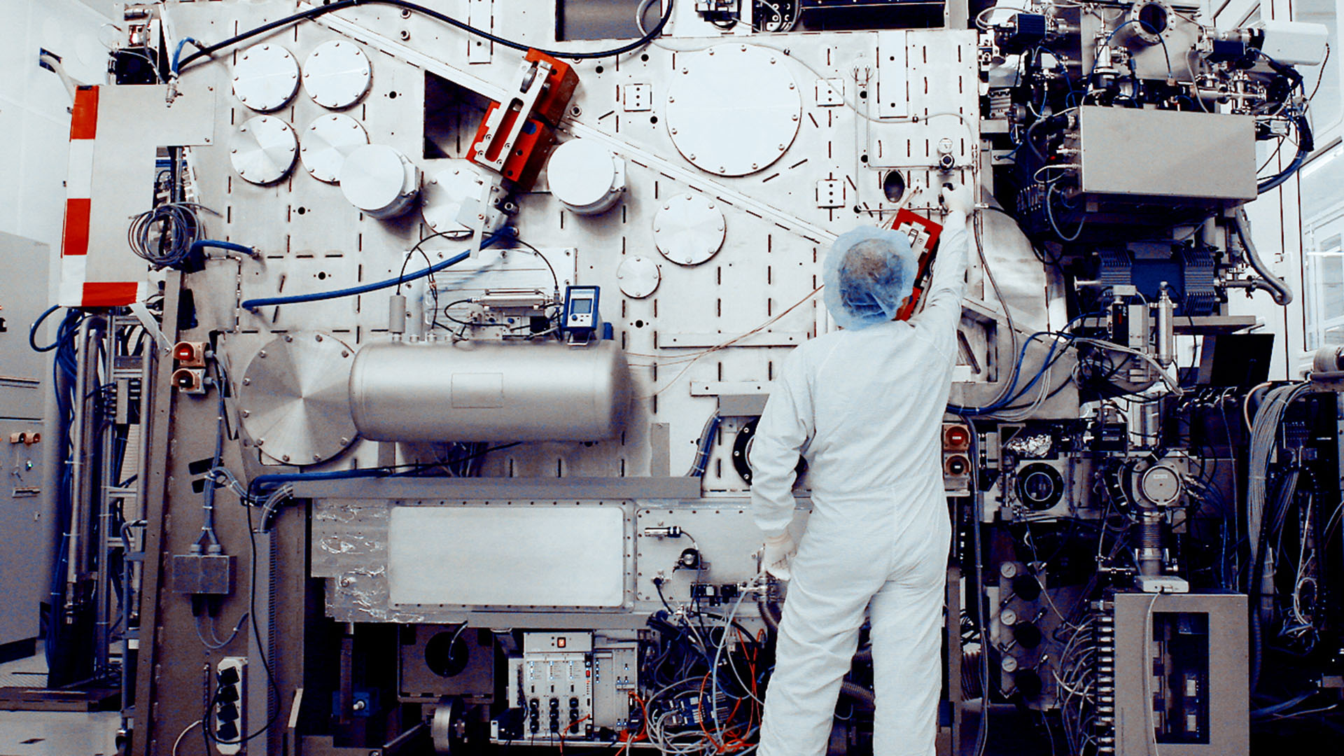 A cleanroom engineer adjusts a knob on a prototype ASML EUV system.